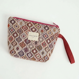 Neceser de jacquard con asa lateral rosa y cierre de cremallera.