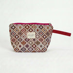 Neceser de jacquard con estampado geométrico en tonos rosa y lila, vista frontal.