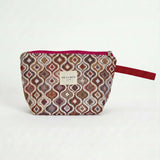 Neceser de jacquard con estampado geométrico en tonos rosa y lila, vista frontal.