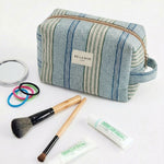 Neceser de jacquard con estampado de rayas en tonos azul, verde agua y beige, vista frontal.