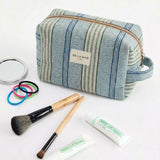 Neceser de jacquard con estampado de rayas en tonos azul, verde agua y beige, vista frontal.