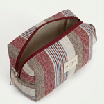 Neceser de jacquard abierto con cremallera superior y forro interior gris.