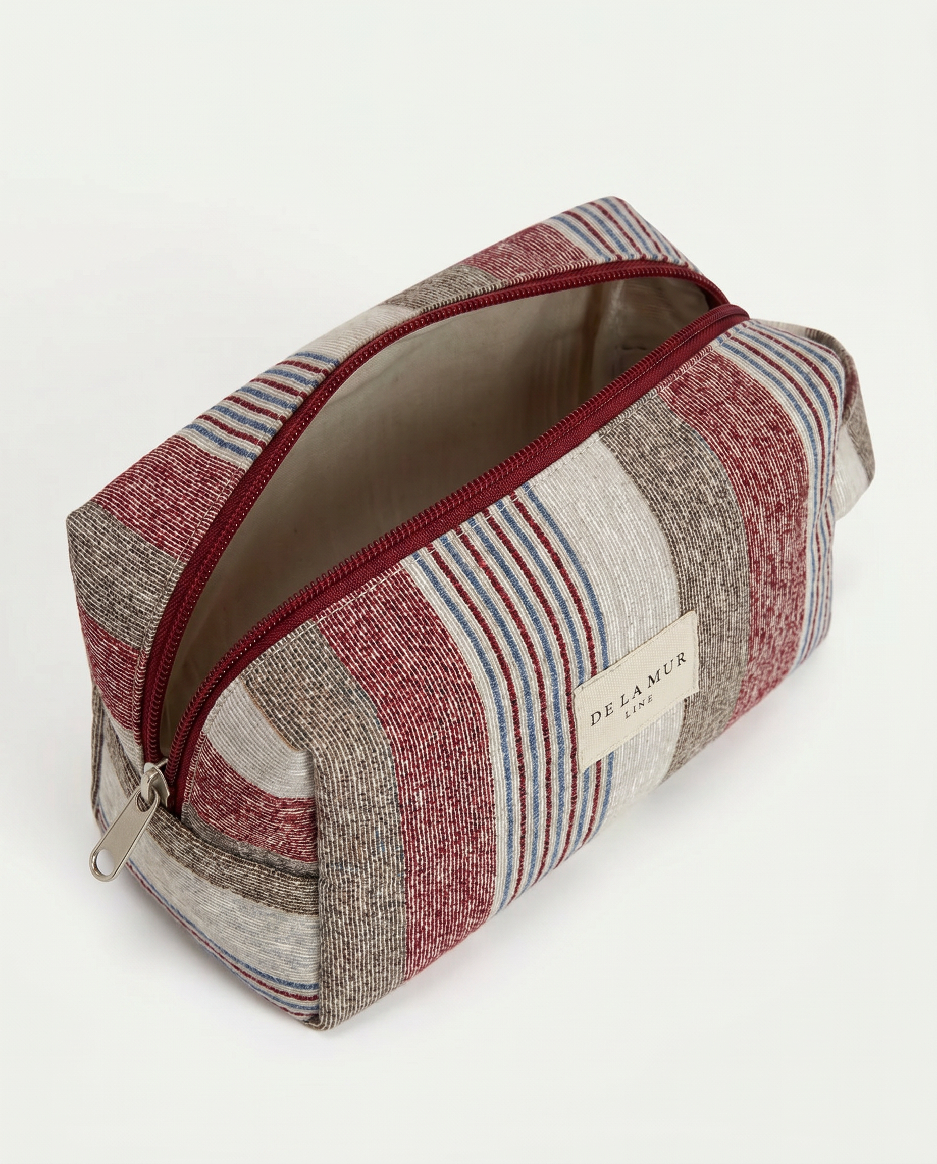 Neceser de jacquard abierto con cremallera superior y forro interior gris.