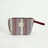 Neceser de jacquard con rayas en tonos granate, azul y crudo, vista frontal.