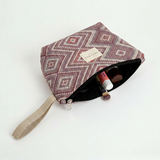Neceser de jacquard abierto mostrando su interior y asa lateral beige.