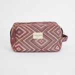 Neceser de jacquard con estampado de rombos en tonos rosa, lila y beige, vista frontal.