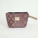 Neceser de jacquard con estampado de rombos en tonos rosa y lila, vista frontal.