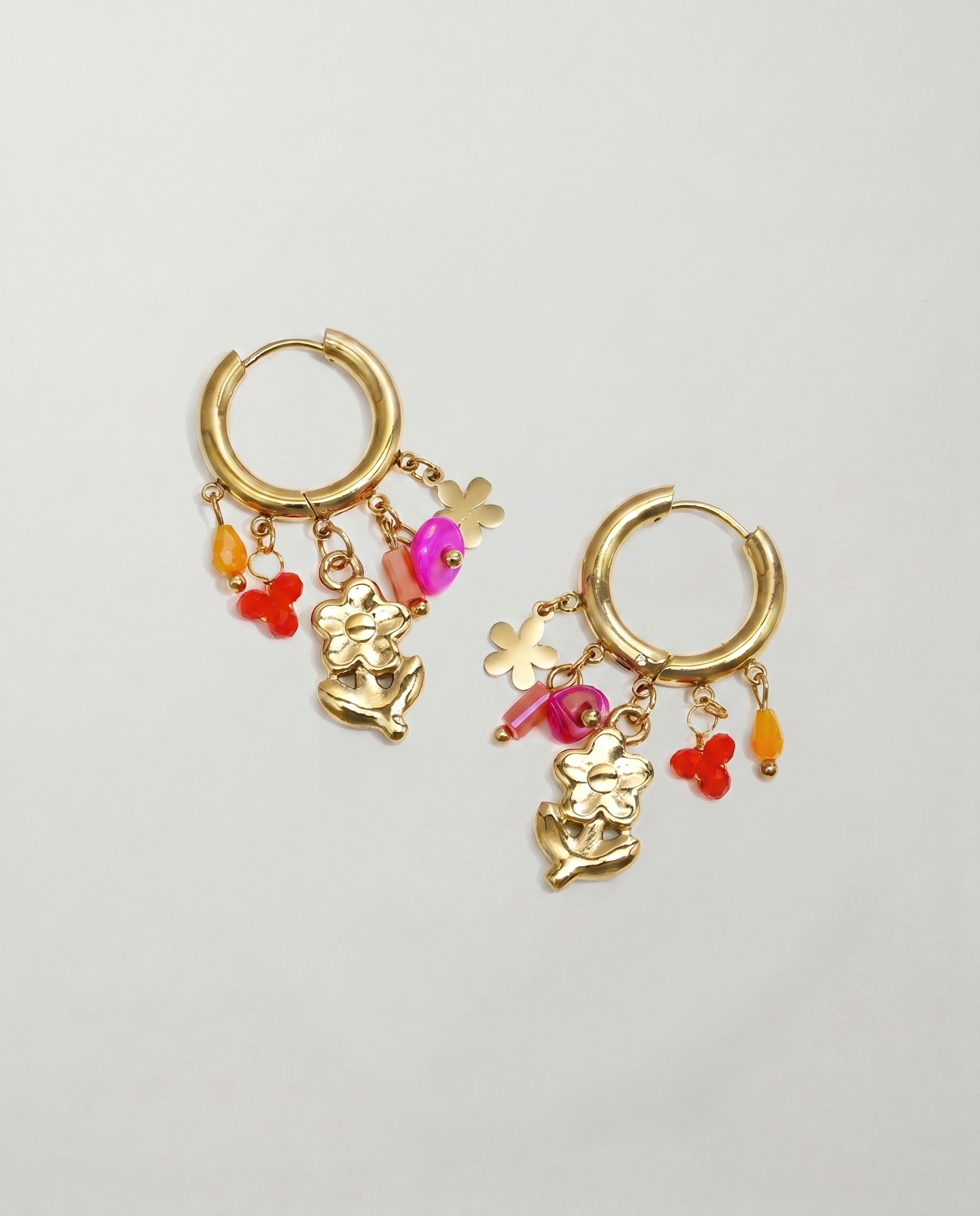 Pendientes de aro dorados con colgante de flor y charms de colores.