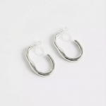 Pendientes de aro ondulado plateados con cierre de clip sobre fondo blanco, vista frontal.