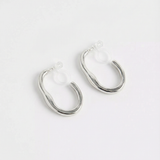Pendientes de aro ondulado plateados con cierre de clip sobre fondo blanco, vista frontal.