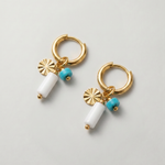 Pendientes de aro dorados con piedra blanca y detalle de piedra turquesa.