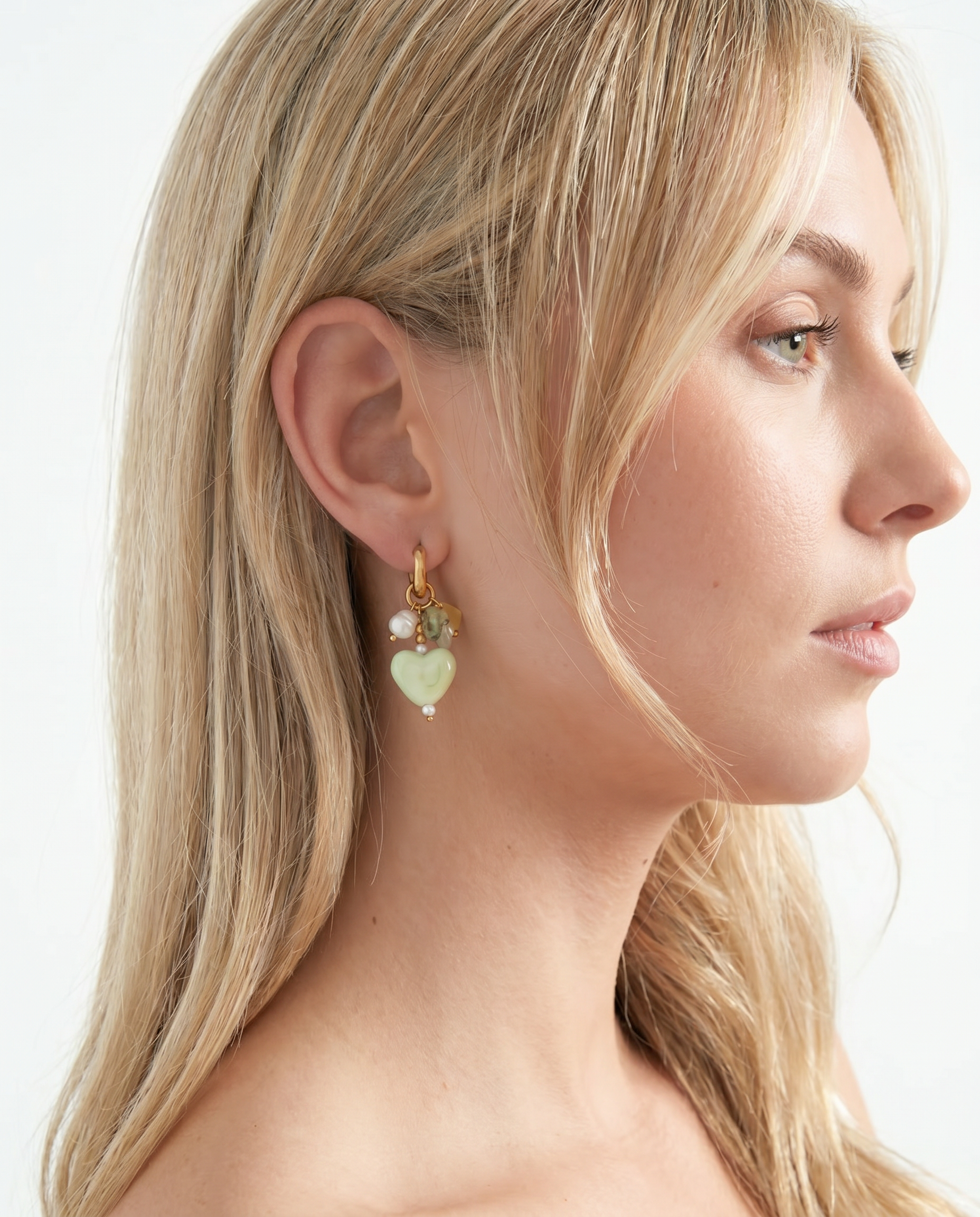 Pendientes de corazón verde estilo Coquette combinados con un look elegante.
