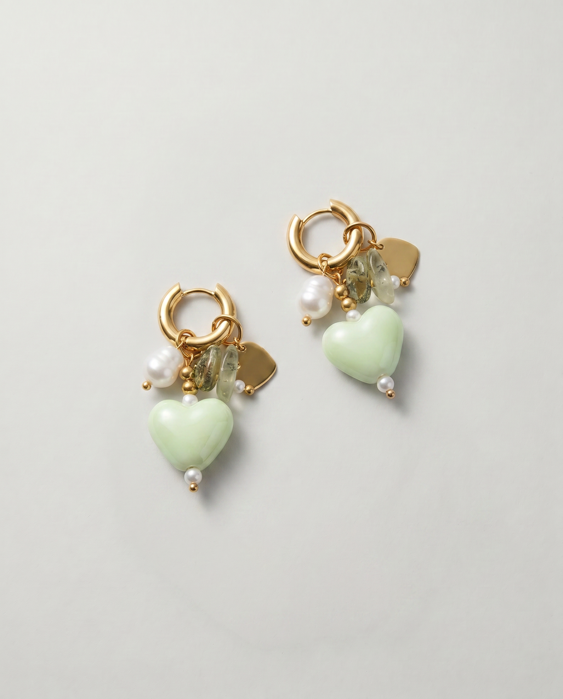 Pendientes dorados con aro y colgante de corazón verde decorado con perla y cristal.