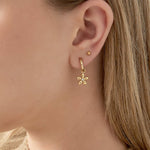 Pendientes dorados con colgante de flor y centro de circonita, vista frontal.

