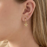 Pendientes dorados con colgante de flor y centro de circonita, vista frontal.

