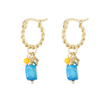 Pendientes dorados con piedra azul rectangular y cuentas amarillas, vista frontal.
