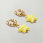 Pendientes de acero inoxidable con aro y estrella amarilla de cerámica.