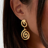 Pendientes colgantes dorados con diseño de doble espiral, vista de perfil