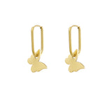 Pendientes dorados colgantes con forma de mariposa sobre fondo blanco.

