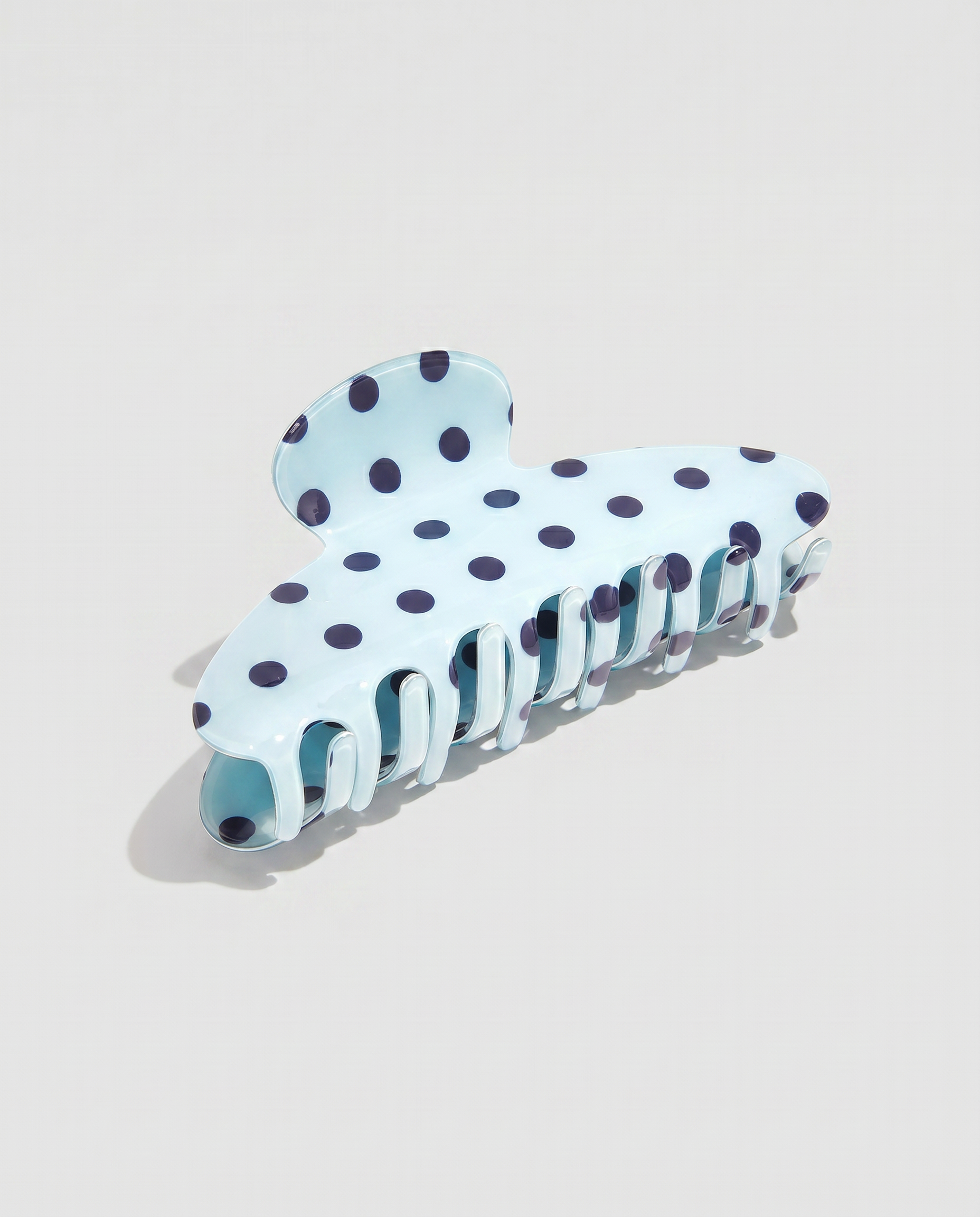 Pinza para el pelo efecto acetato en color azul claro con estampado de lunares azul marino.