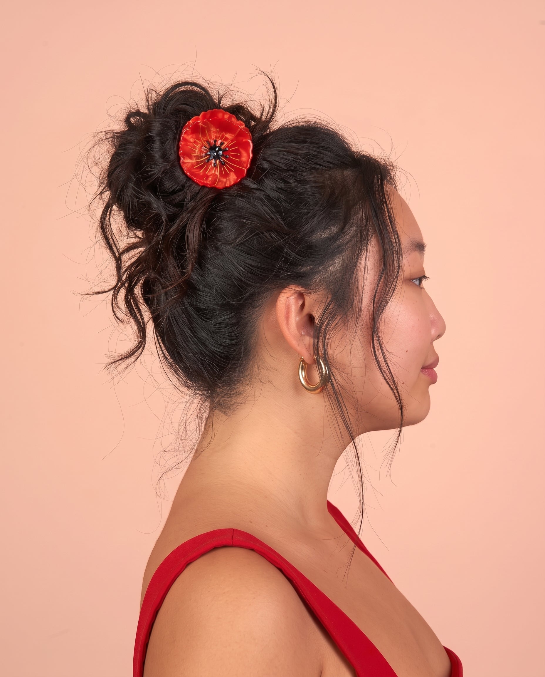 Pinza de pelo con forma de flor roja colocada en un moño.