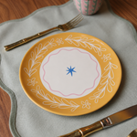 Plato de cerámica amarillo con borde floral y detalle central en azul.