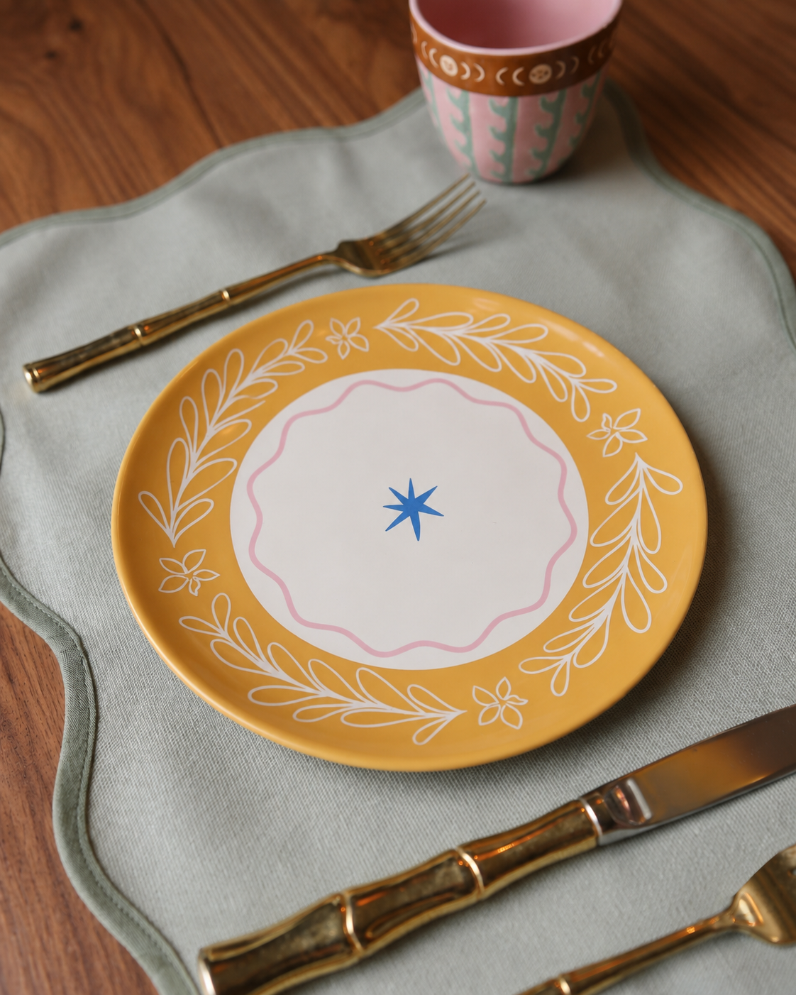 Plato de cerámica amarillo con borde floral y detalle central en azul.