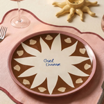 Plato de cerámica decorando una mesa junto a copas y cubiertos.