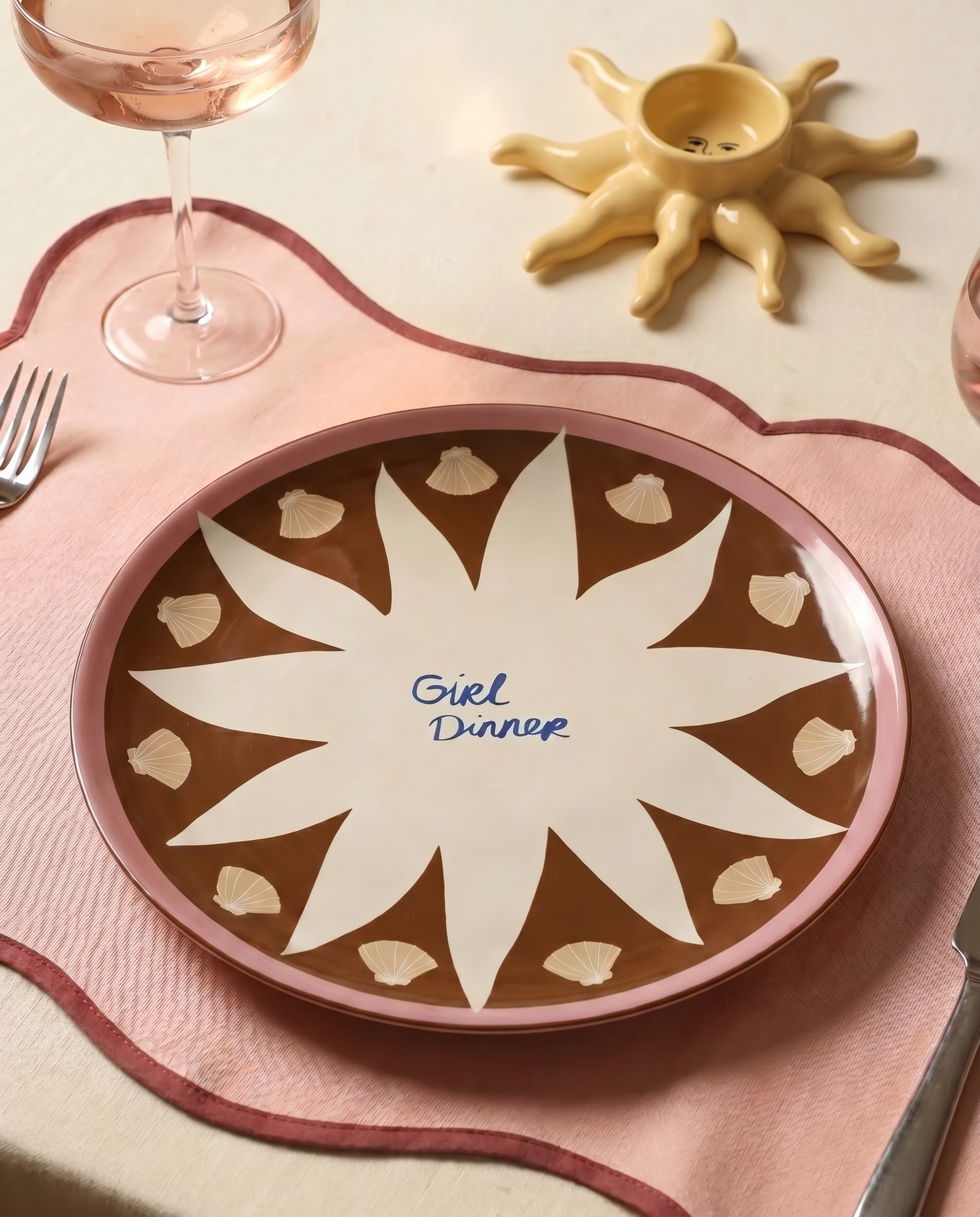 Plato de cerámica decorando una mesa junto a copas y cubiertos.