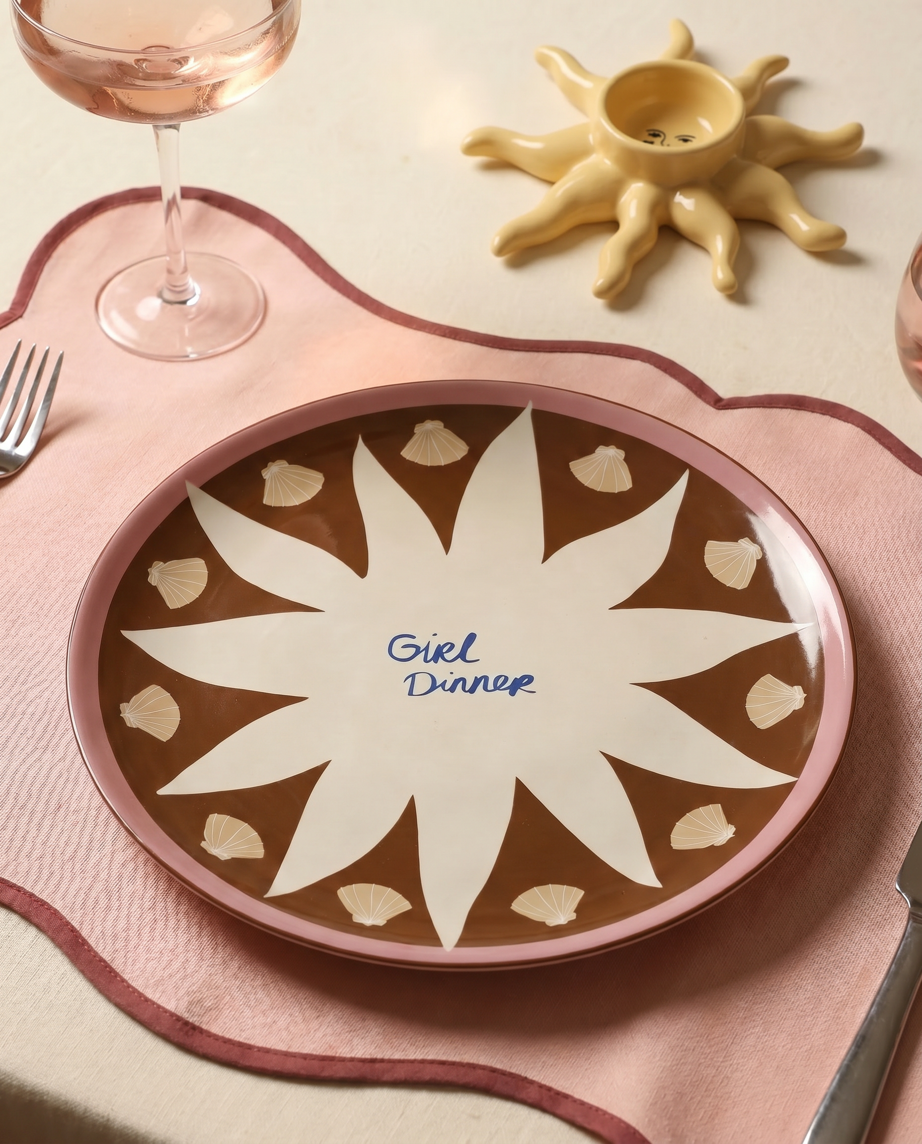 Detalle del plato marrón con ilustración de sol y acabado brillante.