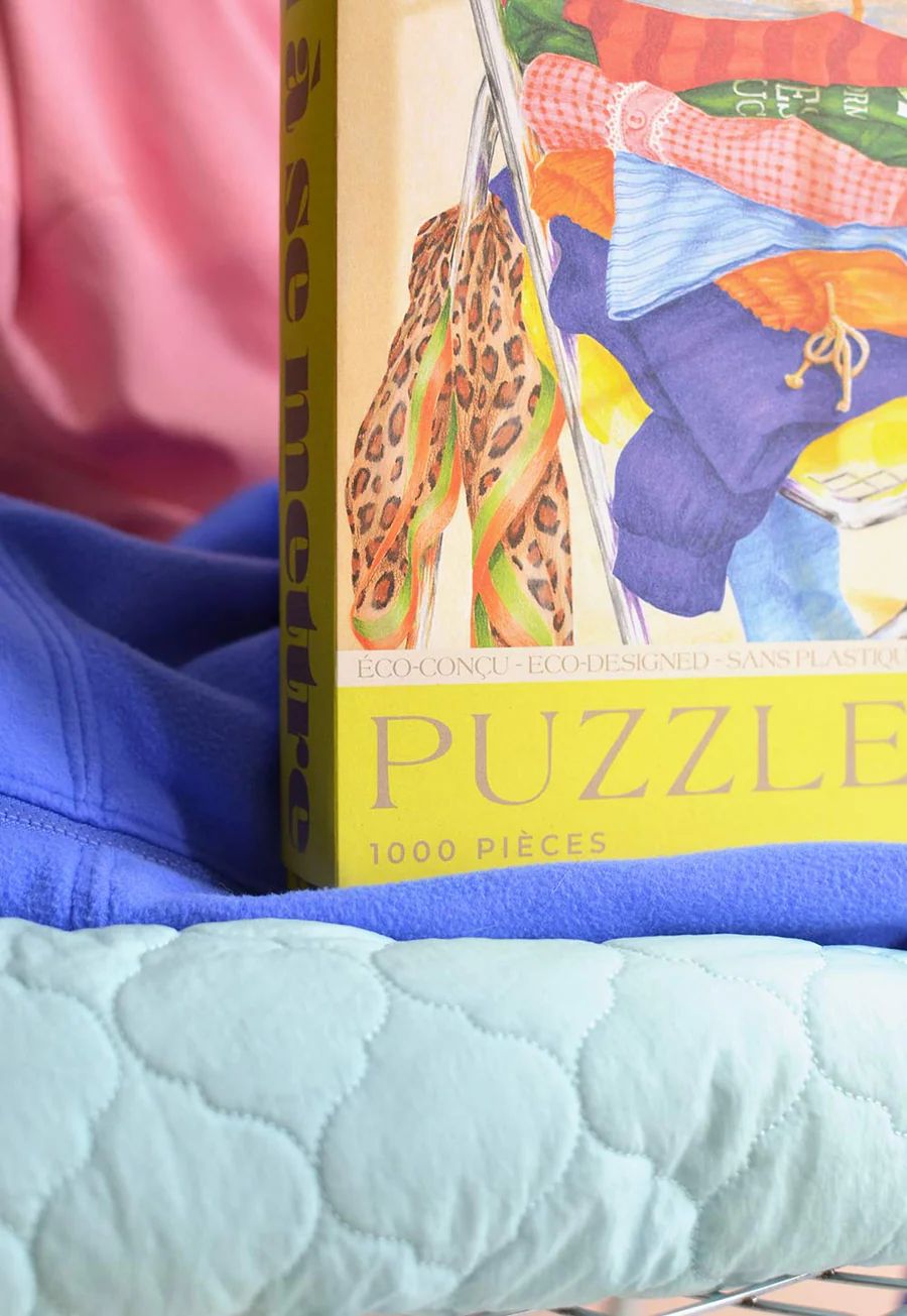 Puzzle artístico de 1000 piezas con ropa en silla. Diseño moderno y sostenible, ideal para amantes de la moda