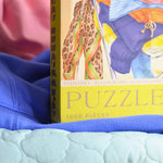 Puzzle artístico de 1000 piezas con ropa en silla. Diseño moderno y sostenible, ideal para amantes de la moda