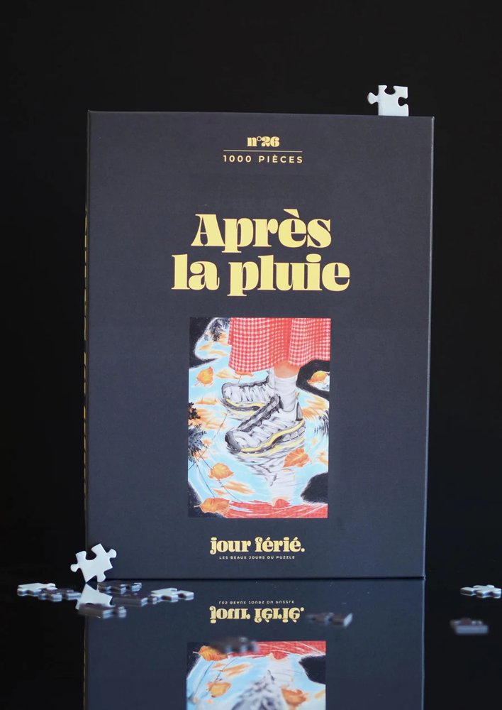 Puzzle de 1000 piezas apilado, con un diseño minimalista y packaging en tonos oscuros y dorados