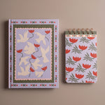 Cuaderno ilustrado con palomas y flores junto a bloc de notas floral del pack Dove & Tulips.
