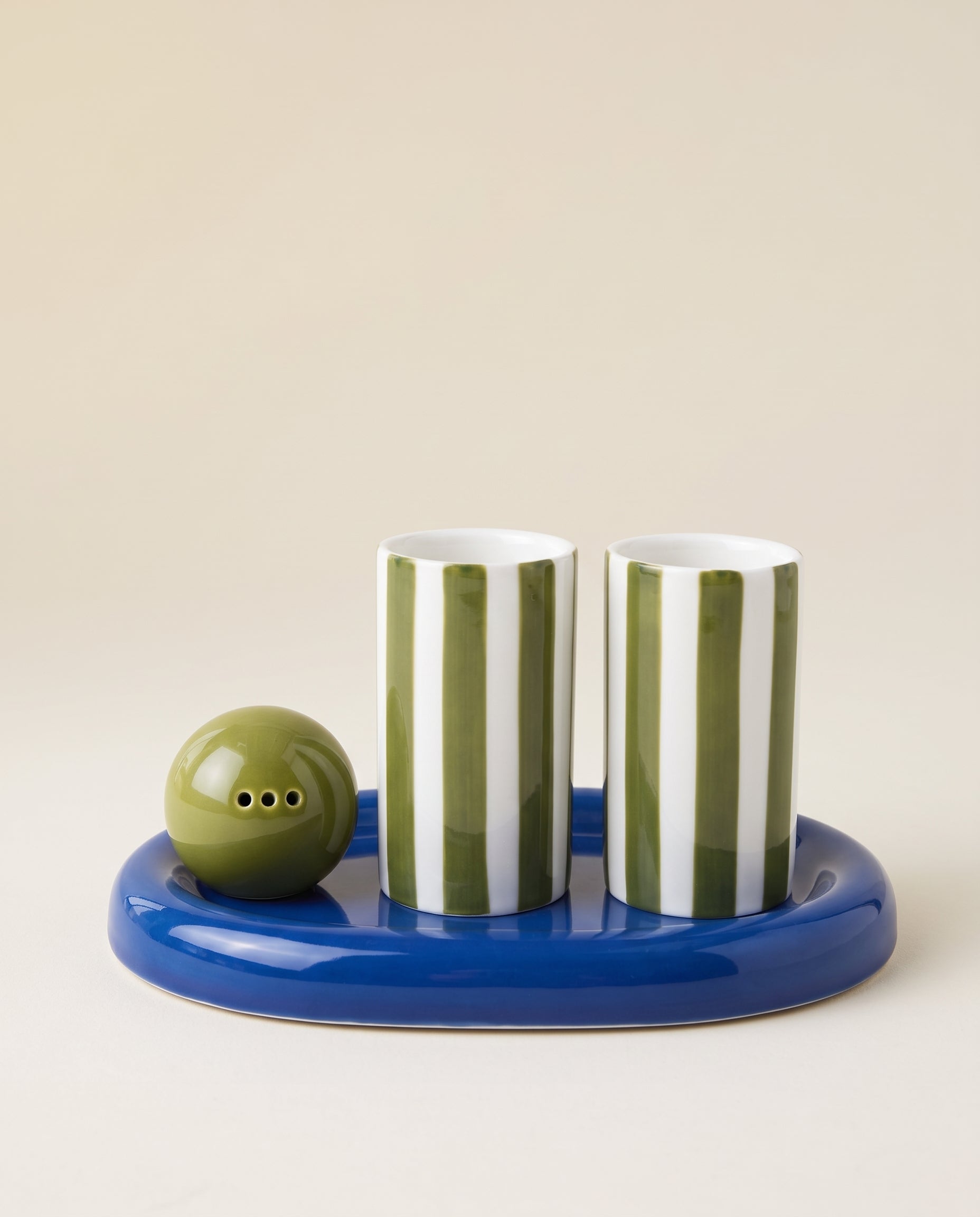 Set de tequila Lily de Here's How con dos vasos de rayas verdes y blancas, salero verde y bandeja azul de cerámica.