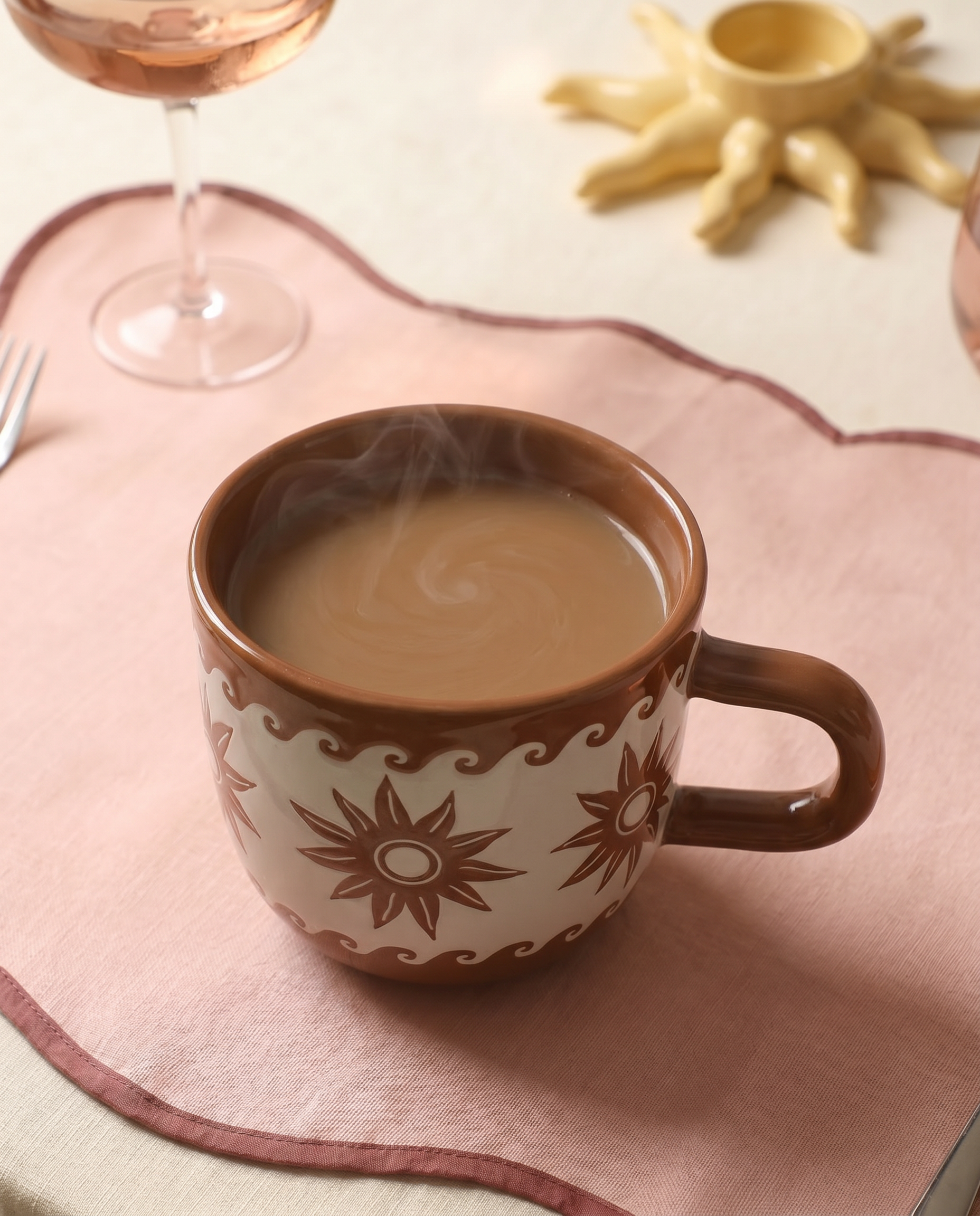 Taza marrón Estrellas y Olas con café caliente.