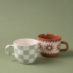Taza marrón Estrellas y Olas junto a otra taza de la colección.