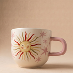 Vista lateral de la taza rosa Sol Sonriente con ilustración de sol y asa rosa.