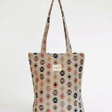Vista frontal de la bolsa tote de jacquard con estampado étnico.