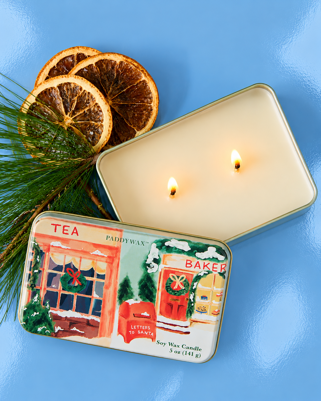 Vela de soja PADDYWAX abierta con dos mechas en recipiente metálico decorativo navideño.