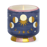 Vela en cerámica pintada a mano con fases lunares doradas y base rosa con rayas.
